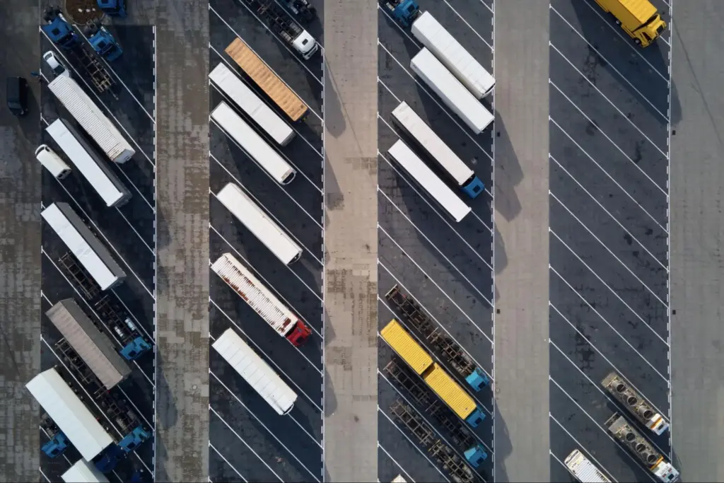 affrètement et organisation des transports : Vue aérienne d'un parc de camions stationnés près d'un entrepôt logistique.